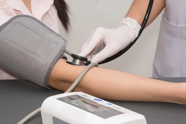 Junger Arzt misst Blutdruck des Patienten — Stockfoto