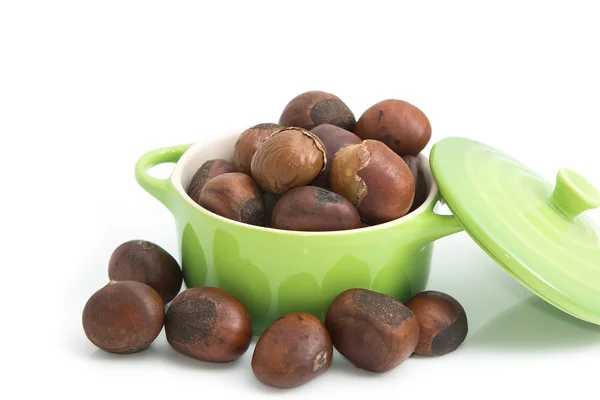 Roasted chestnuts in green bowl on white background — Stock Photo, Image