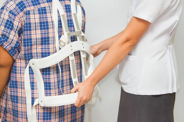 Корсет для травми спини. фізіотерапевт допомагає пацієнту — стокове фото