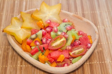 Renkli doğal meyve salatası içinde ahşap darbe