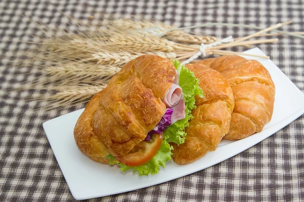 Sándwiches de croissant en plato blanco, desayuno por la mañana —  Fotos de Stock