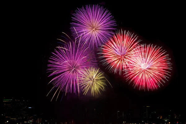 Färgglada fyrverkerier över natten himmel, röda fireworks linjer i svart b — Stockfoto