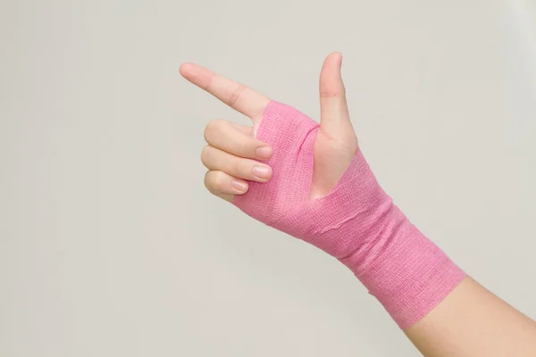 Junge Frau mit rosa Verband mit Schmerzen im Handgelenk — Stockfoto