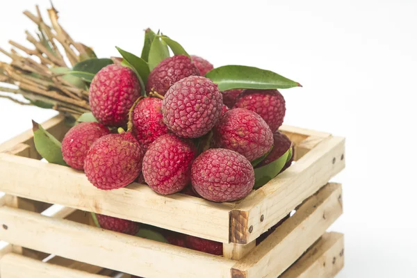 Färska litchi i en trälåda på en vit bakgrund — Stockfoto