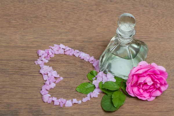 Бутылки эфирного масла с цветами роз и солью, ароматерап — стоковое фото