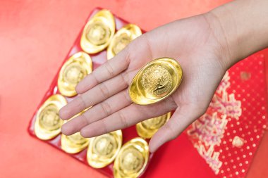 Kırmızı Çin Yeni Yılı kutlamaları için Altın külçe veren el 