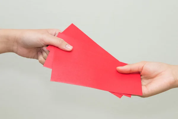 Woman hand giving red envelop containing money, during Chinese N — Stock Photo, Image