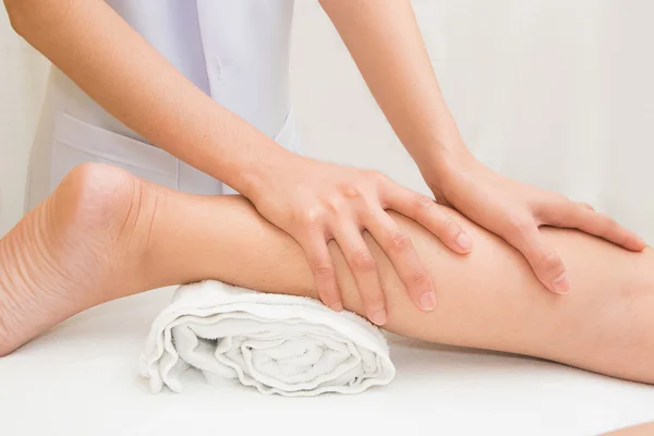 Терапевт робить масаж на нозі жінки в денному спа-центрі — стокове фото