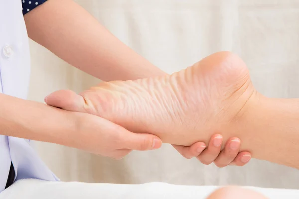 Terapeuten gör massage på kvinnan ben i dagspa — Stockfoto