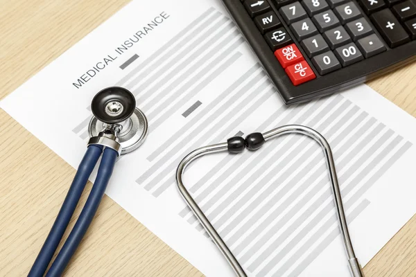 Stethoscope and calculator laying on the blank of medical insura — Stock Photo, Image