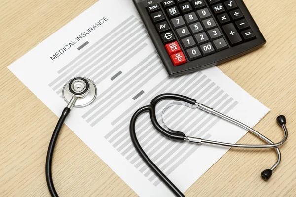 Stethoscope and calculator laying on the blank of medical insura — Stock Photo, Image