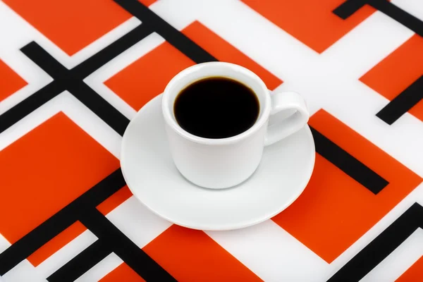 Cup with black drink inside on a black and white and red backgro