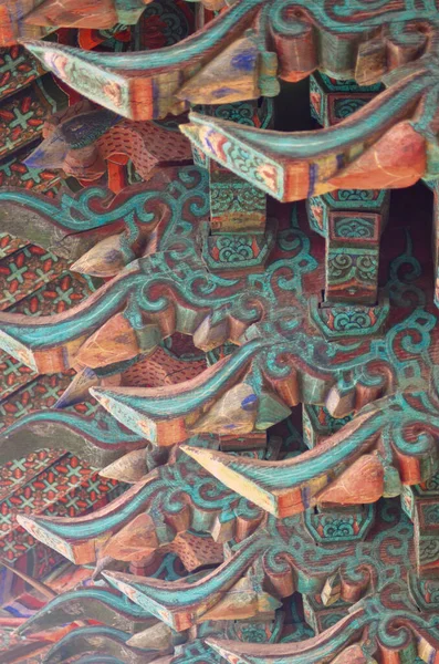 Kore 'de bir tapınağın çatısı ahşap kirişler oyulmuş ve geometrik mavi ve kırmızı desenlerle boyanmış..