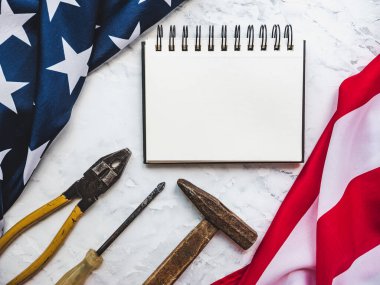 İLK GÜNÜ. El aletleri ve Amerika Birleşik Devletleri bayrağı masanın üzerinde yatıyordu. Yukarıdan bak, yakın plan. Ailenizi, akrabalarınızı, arkadaşlarınızı ve iş arkadaşlarınızı tebrik ederim. Ulusal tatil konsepti