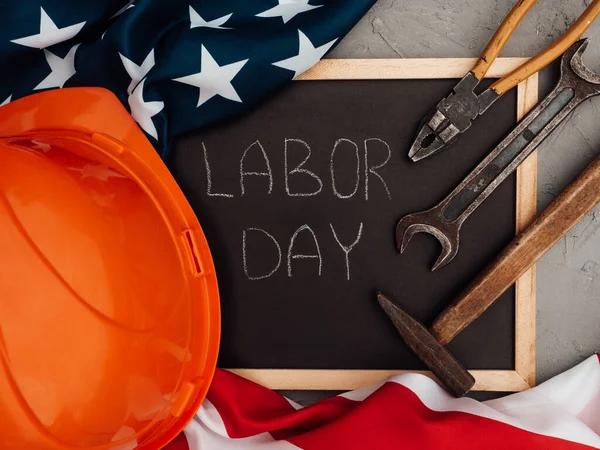 LABOR DAY. Hand tools and the Flag of the United States of America lying on the table. View from above, close-up. Congratulations to family, relatives, friends and colleagues. National holiday concept