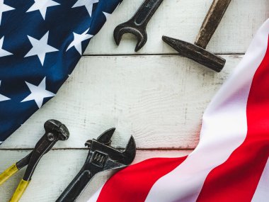 İLK GÜNÜ. El aletleri ve Amerika Birleşik Devletleri bayrağı masanın üzerinde yatıyordu. Yukarıdan bak, yakın plan. Ailenizi, akrabalarınızı, arkadaşlarınızı ve iş arkadaşlarınızı tebrik ederim. Ulusal tatil konsepti