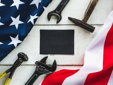 İLK GÜNÜ. El aletleri ve Amerika Birleşik Devletleri bayrağı masanın üzerinde yatıyordu. Yukarıdan bak, yakın plan. Ailenizi, akrabalarınızı, arkadaşlarınızı ve iş arkadaşlarınızı tebrik ederim. Ulusal tatil konsepti