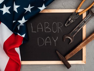 İLK GÜNÜ. El aletleri ve Amerika Birleşik Devletleri bayrağı masanın üzerinde yatıyordu. Yukarıdan bak, yakın plan. Ailenizi, akrabalarınızı, arkadaşlarınızı ve iş arkadaşlarınızı tebrik ederim. Ulusal tatil konsepti
