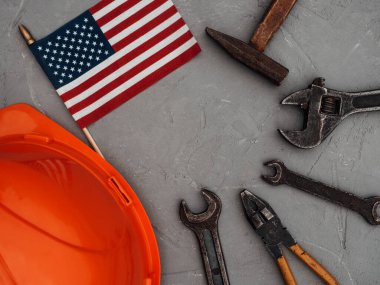 İLK GÜNÜ. El aletleri ve Amerika Birleşik Devletleri bayrağı masanın üzerinde yatıyordu. Yukarıdan bak, yakın plan. Ailenizi, akrabalarınızı, arkadaşlarınızı ve iş arkadaşlarınızı tebrik ederim. Ulusal tatil konsepti
