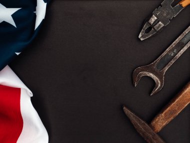 İLK GÜNÜ. El aletleri ve Amerika Birleşik Devletleri bayrağı masanın üzerinde yatıyordu. Yukarıdan bak, yakın plan. Ailenizi, akrabalarınızı, arkadaşlarınızı ve iş arkadaşlarınızı tebrik ederim. Ulusal tatil konsepti