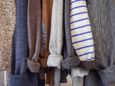 Soyunma odasındaki askılarda sonbahar ve kış giysileri asılı. Kimse yok, yakın plan. Güzellik ve moda kavramı