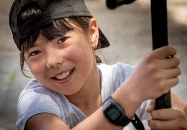 Kameranın önünde neşeli bir şekilde poz veren Asyalı güzel esmer bir kızın portresi.