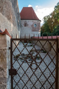 Büyük ve yüksek duvarın yanındaki paslı kapı.