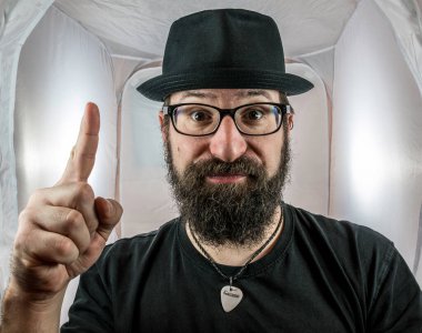 Şapkalı ve gözlüklü sakallı bir adamın bir fikri vardır.