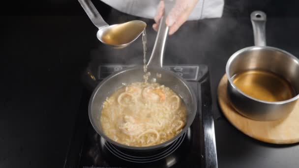 Restaurante italiano de mariscos. Vista superior. chef verter caldo de pescado de cucharón en risotto. En cámara lenta. Cocina tradicional italiana. Full hd — Vídeos de Stock