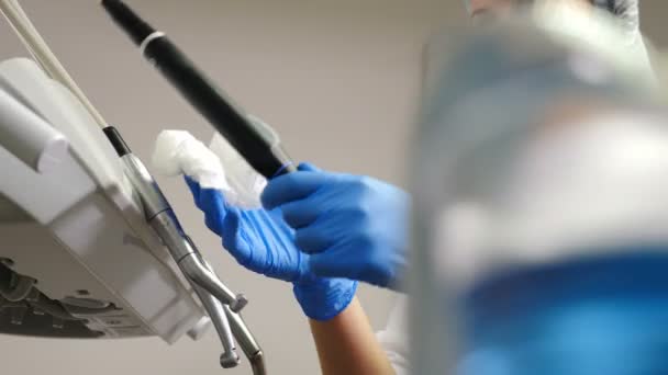 A fogászati asszisztens fertőtlenítő oldattal törli az orvostechnikai eszközöket és eszközöket. Orvosi fogászati egység feldolgozása, tisztítása, sterilizálása és fertőtlenítése a fogászatban, orvosi rendelő. 4 k — Stock videók