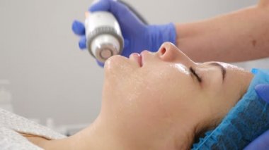 Güzellik kliniğinde cerrahi olmayan yüz gerdirme. Kozmetik uzmanı, müşteri yüzünde manipülatörü hareket ettiriyor. Profesyonel güzellik uzmanı güzellik salonunda yüz prosedürleri yapar. Kozmetik yenilikleri. 4k video