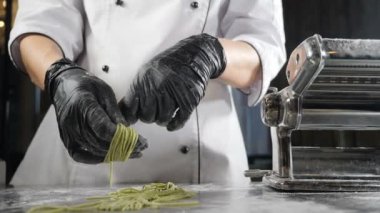 Ev yapımı makarna yapıyorum. Çiğ spagetti ya da tagliatelle kıvıran kadın elleri. Ağır çekim. Bir sürü pişmemiş İtalyan makarnası. Geleneksel İtalyan mutfağı. Tam Hd