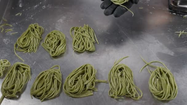 Göra hemlagad pasta. Kvinnliga händer som lägger okokt spaghetti eller tagliatelle på tallriken. Göra nudlar. Massor av okokt italienskt pastafettuccin. Traditionell italiensk mat. Fullständig hd — Stockvideo