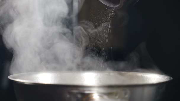 Witte rook in slow motion stijgt boven hete koekenpan op zwarte achtergrond. Koken in het restaurant. Heerlijke schotel wordt gekookt in de keuken. Stoom- of dampwolken. Vol hd — Stockvideo