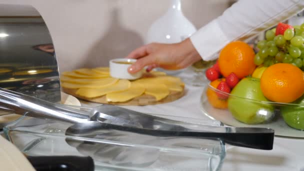 Obsługa bufetu w hotelu. Kelnerka serwuje stół z miodem na serze umieszczonym na drewnianej desce. Restauracja serwująca jedzenie. Śniadanie w formie bufetu w luksusowej restauracji hotelowej resort z różnorodnym jedzeniem — Wideo stockowe