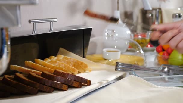 Сучасний готель пропонує сніданок "шведський стіл". концепція харчування. Жінка-офіціант поклала шматочок хліба в сталевий хлібний кошик на столі. Все включено. Буфетна їжа. Гарно прикрашений стіл для громадського харчування. 4 к — стокове відео
