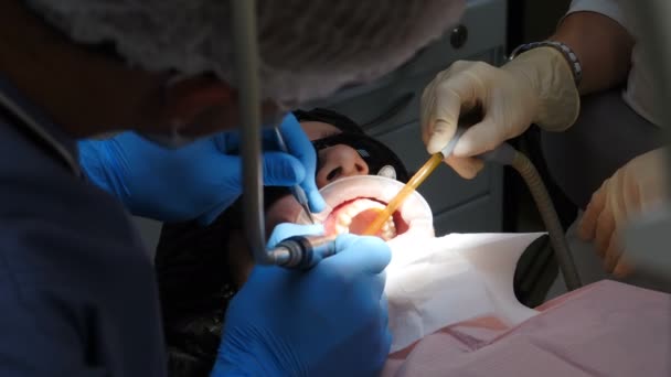 牙齿和牙齿护理的概念。安装供应商的过程。放置在现代牙医学中的鹿角。女性病人在设有瓷窗安装程序的椅子上的特写镜头，4k — 图库视频影像