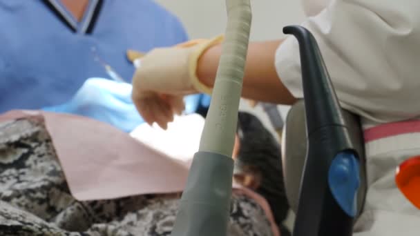 Concepto de cuidado dental y dental. proceso de instalación de chapas. Entorno de carillas en odontología moderna. Primer plano del paciente femenino en silla que tiene chapas de porcelana procedimiento de instalación, 4 k — Vídeo de stock