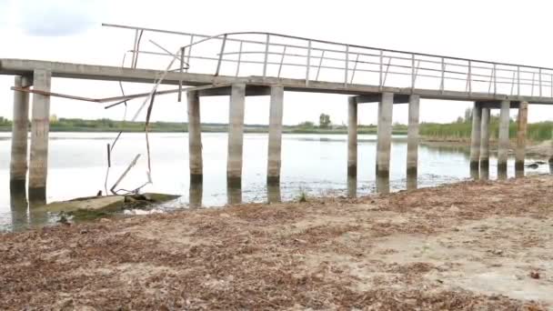 Ecologische ramp. gebarsten grond en gebroken brug over gedroogd meer of rivier. Land verwoest door erosie en opwarming van de aarde - Klimaatverandering en ecologische kwesties. Vol hd — Stockvideo