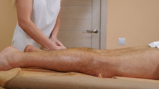 Koncepcja opieki zdrowotnej. Lekarz terapeuta wykonujący ręczny drenaż limfatyczny masaż antycellulitowy do pacjenta leżącego na stole do masażu. Profesjonalny masaż męskich nóg. 4 tys. wideo — Wideo stockowe