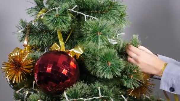Navidad y feliz año nuevo símbolos. Mujer decorando árbol de Navidad con pelotas y juguetes, primer plano, vacaciones de invierno preparación de temporada festiva, celebración de Año Nuevo. 4 k vídeo — Vídeo de stock