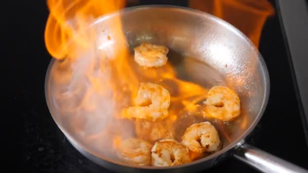 Chef prepara langostinos con fuego en la sartén en la cocina del restaurante. En cámara lenta. Plato de mariscos cocinado en llama ardiente. Estilo Flambe. Cocinar ingredientes para ensalada. Full hd — Vídeos de Stock