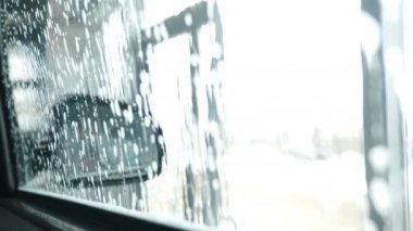 Robot araba yıkama makinesi. İçeriden bak. Araba camı sabunla kaplanmış. Araba yüzeyinde küçük bir deterjan damlası. Araba yıkama servisi iş başında. Hızlı ve kullanışlı. 4k video