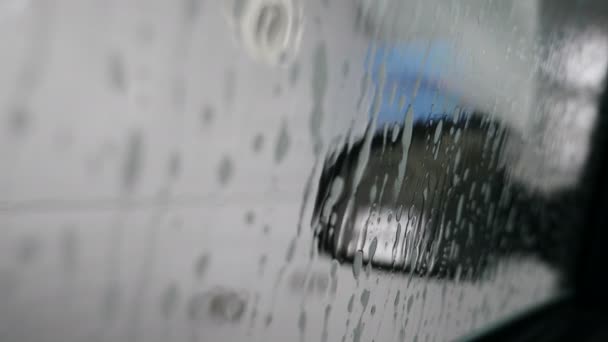 Vista desde el interior del coche que se lava en la máquina automática de lavado de coches. Servicio de lavado de coches en acción. Parte del proceso de lavado. Flujo de agua a alta presión. Rápido y conveniente. 4 k vídeo — Vídeo de stock