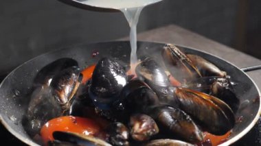 Lüks restoran. Sıcak buharlı lezzetli midyeler pişirmek. Ağır çekim. Sıvı dolu bir kap. Geleneksel Akdeniz mutfağı. Deniz mahsullü makarna. Tam Hd