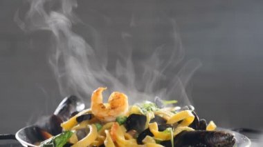 Geleneksel karidesli deniz ürünleri makarnası ve ağır çekimde buhar. Buhar ya da buhar ağır çekimde yükseliyor. Ev yapımı karides makarnası. Geleneksel İtalyan mutfağı. Tam Hd