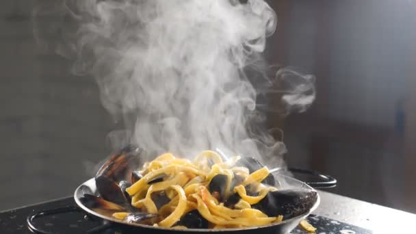 ブリックを背景にエビやムール貝を皿の上で蒸しシーフードスパゲティ。蒸気または蒸気がスローモーションで上昇します。自家製のエビパスタ。伝統的なイタリア料理。フルHD — ストック動画