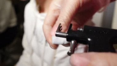 Piercing işlemi için hazırlık. Kozmetik uzmanı alkol solüsyonuyla temizleyen tıbbi bir cihaz hazırlıyor. - Evet. Tıp çalışanı kulak kıkırdağında delik açıyor. Tıbbi alet dezenfeksiyonu. 4k video