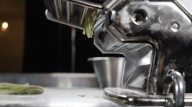 Sağlıklı İtalyan yemekleri. Makarna makinesinden makarna yapmak. Ağır çekim. Restoran yemekleri. Yuvarlanan makineden ev yapımı erişte yapıyorum. Taze spagetti geliyor. Tam Hd