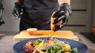 Patates kızartması ve böğürtlenli deniz ürünleri. Izgara ahtapot dokunaçlarında kesilmiş meyveden meyve suyu ve tohum damlıyor. Tazelik, tropik egzotik meyve ve vitamin. Ağır çekim. Tam Hd